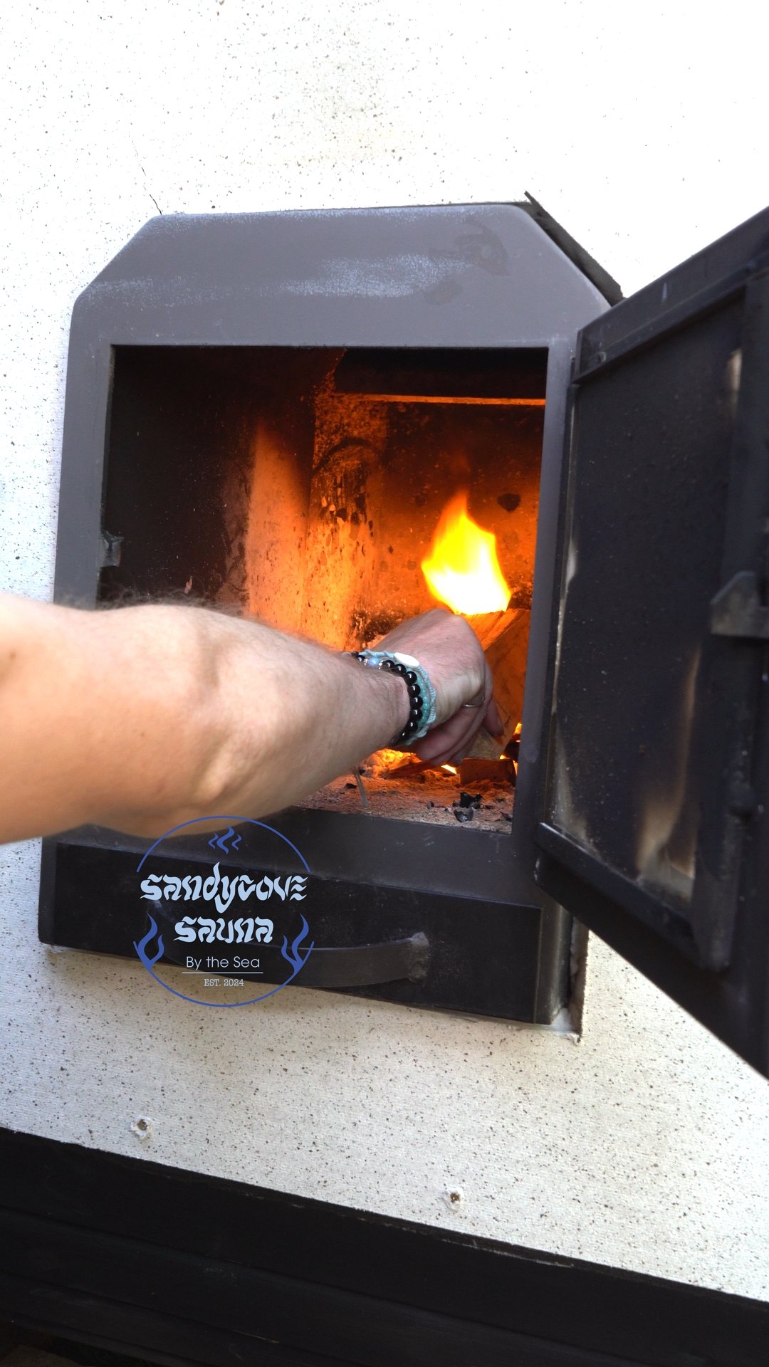 Adding logs to the wood-fired sauna